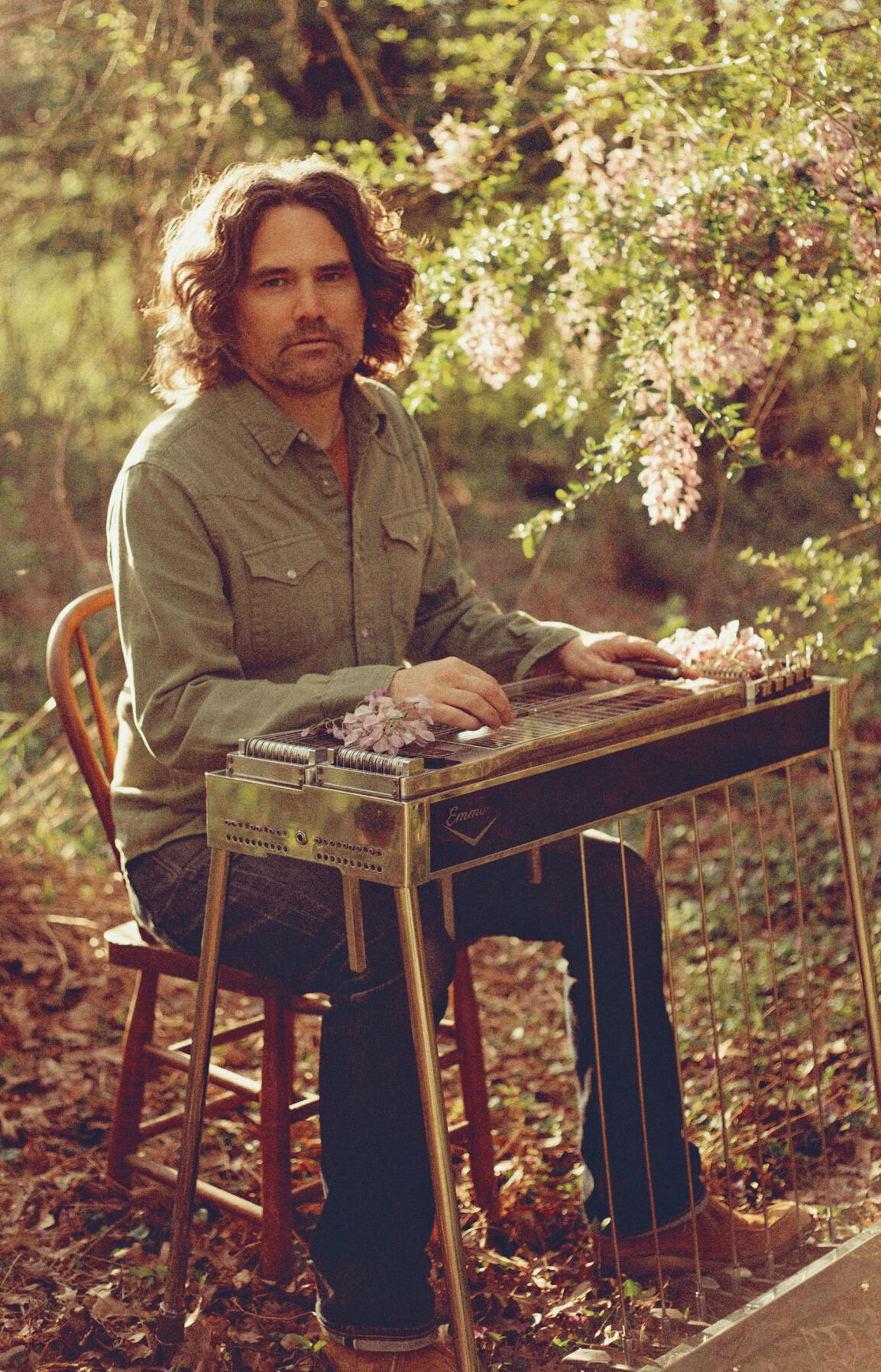 Luke Schneider press photo artist plays pedal steel in a forest